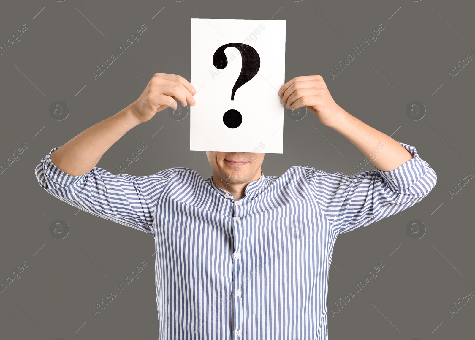 Photo of Man holding paper with question mark on grey background