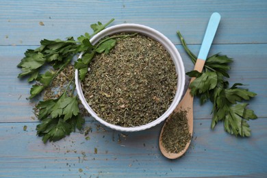 Photo of Dried parsley and fresh leaves on light blue wooden table, flat lay