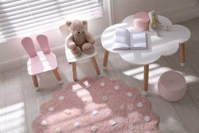 Photo of Round pink rug on floor in children's room, above view
