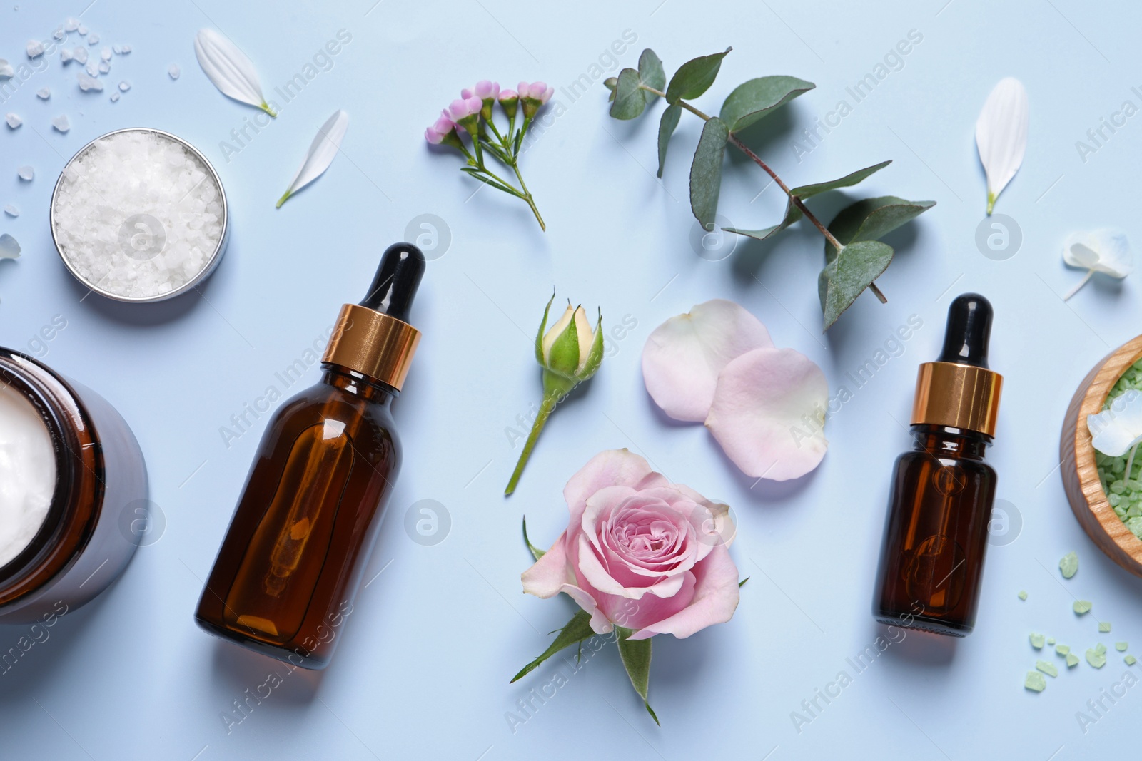 Photo of Flat lay composition with cosmetic serum on light blue background