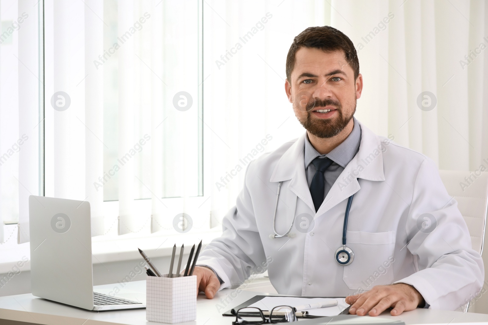 Photo of Portrait of male doctor in white coat at workplace