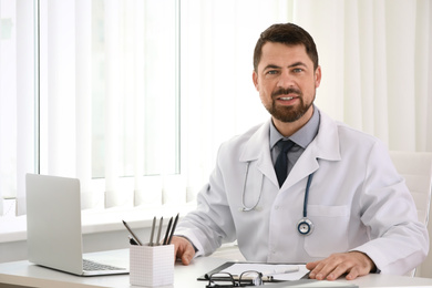 Photo of Portrait of male doctor in white coat at workplace