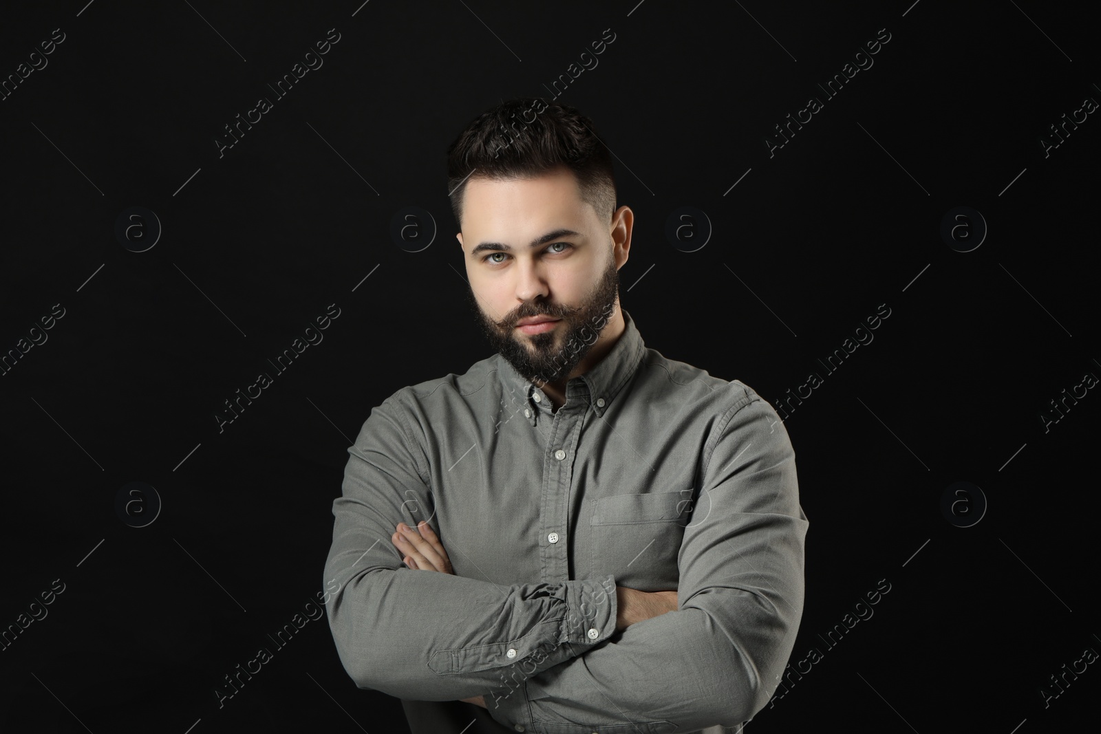 Photo of Portrait of young man with mustache on black background