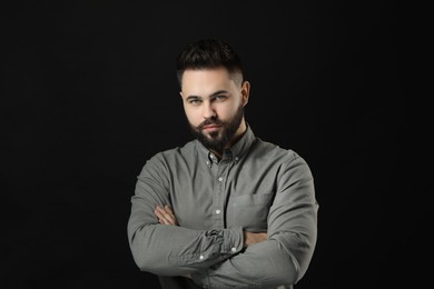 Portrait of young man with mustache on black background