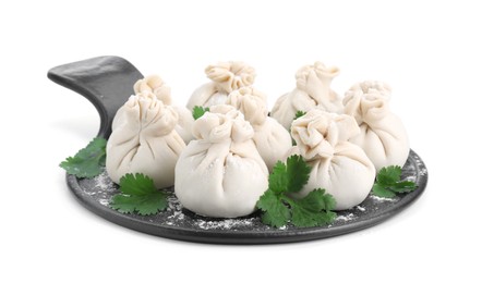Board with uncooked khinkali (dumplings) and parsley isolated on white. Georgian cuisine