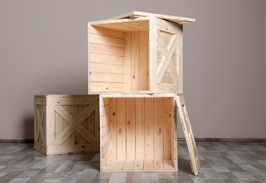 Photo of Wooden crates on floor at beige wall. Space for text