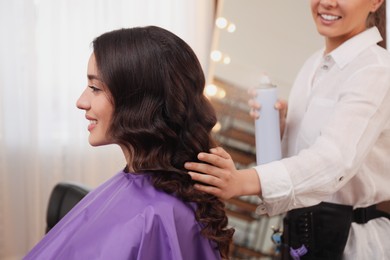 Photo of Stylist working with client in salon, making hairstyle