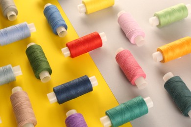 Set of different sewing threads on color background