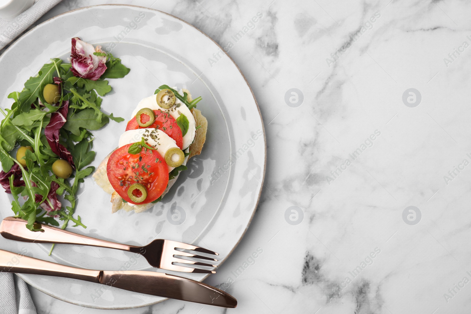 Photo of Flat lay composition of tasty bruschetta with tomatoes and salad served on white marble table. Space for text