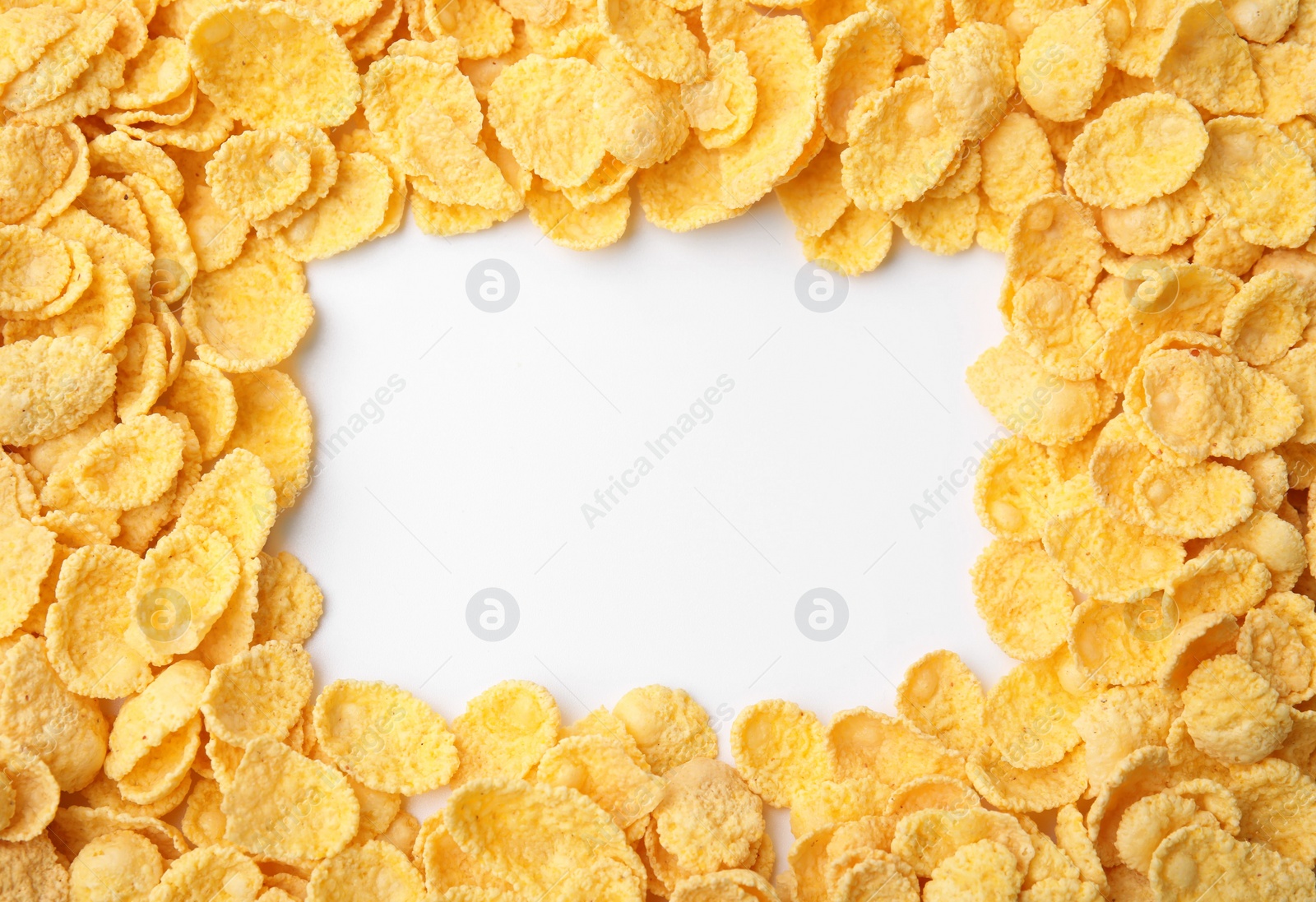 Photo of Frame made of tasty corn flakes on white background, top view. Space for text