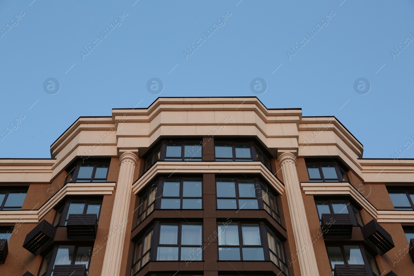 Photo of Facade of beautiful residential building against blue sky, low angle view