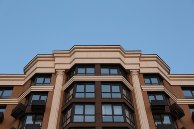 Photo of Facade of beautiful residential building against blue sky, low angle view