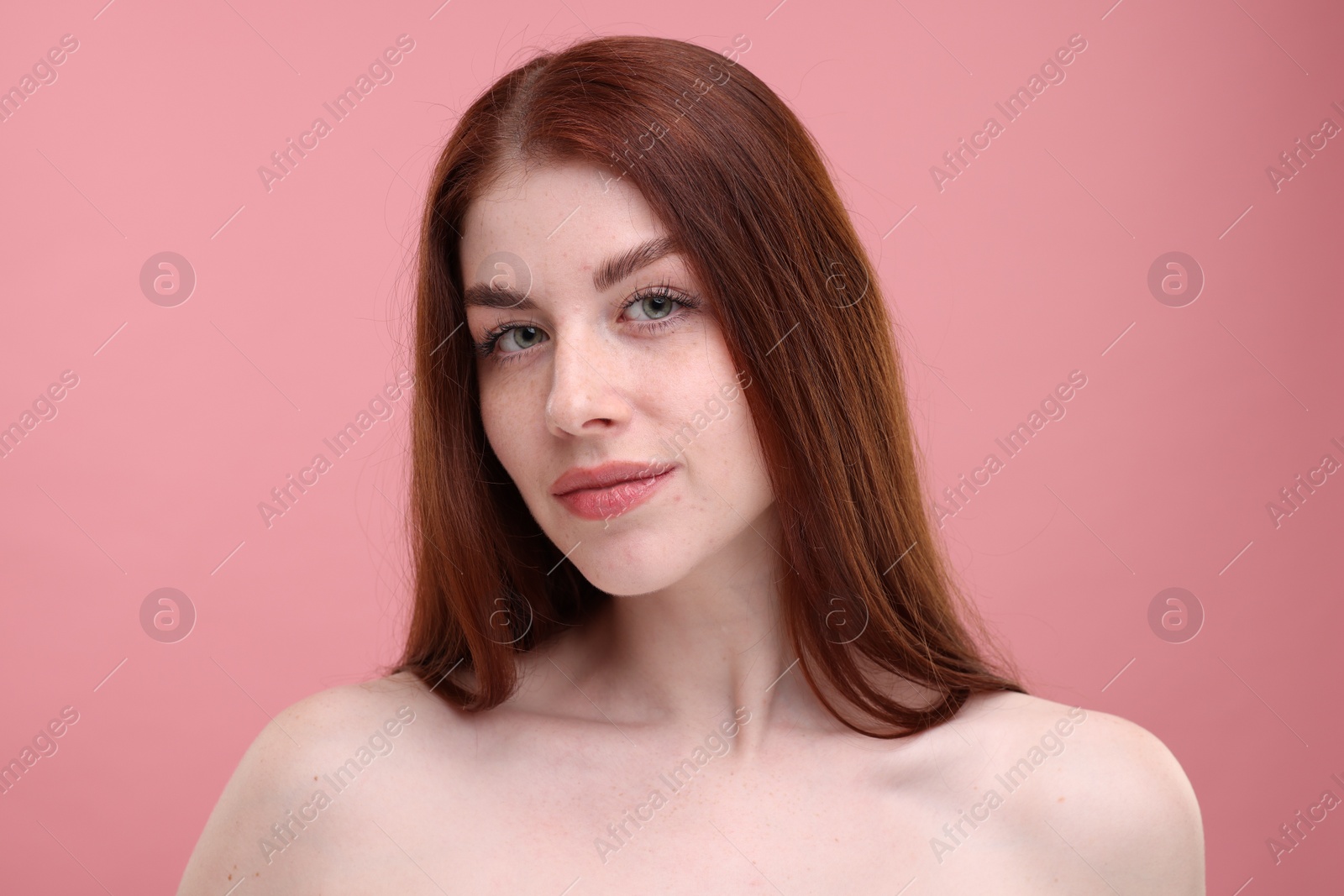 Photo of Portrait of beautiful woman with freckles on pink background