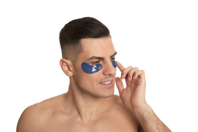 Photo of Man applying blue under eye patch on white background