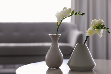 Photo of Beautiful spring freesia flowers on white table in room