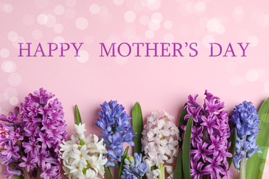 Image of Flat lay composition with beautiful spring flowers and phrase HAPPY MOTHER'S DAY on light pink background