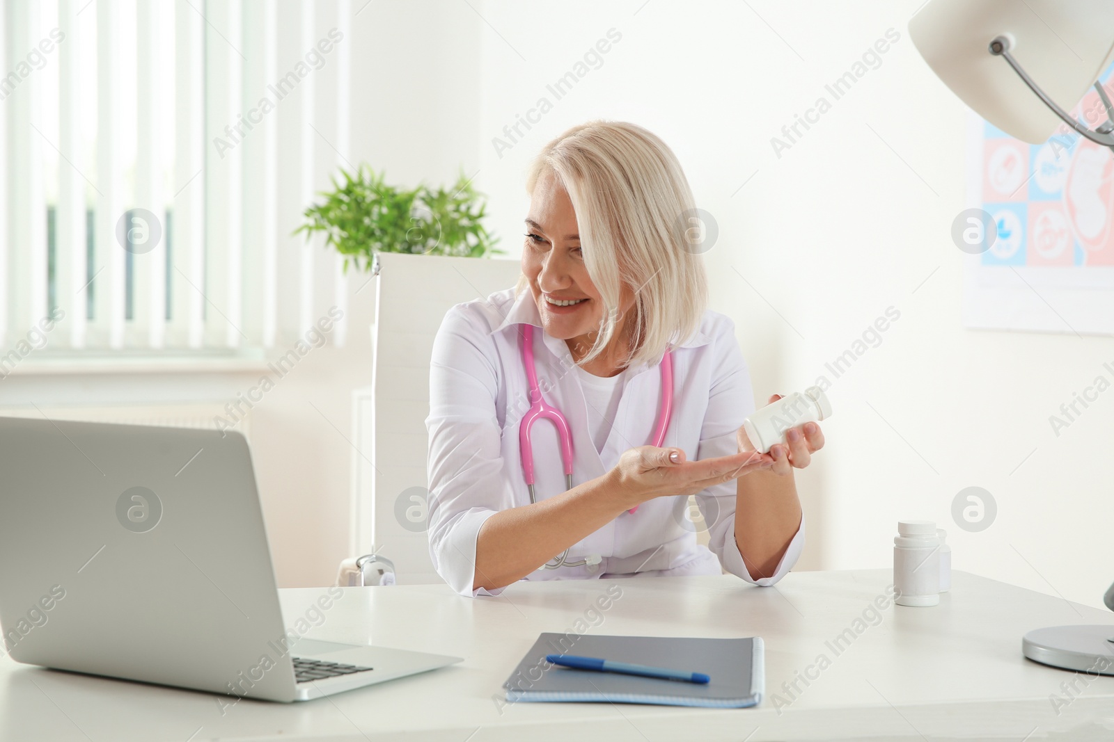 Photo of Doctor consulting patient using video chat on laptop in clinic