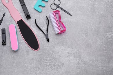 Photo of Set of pedicure tools on light gray table, flat lay. Space for text