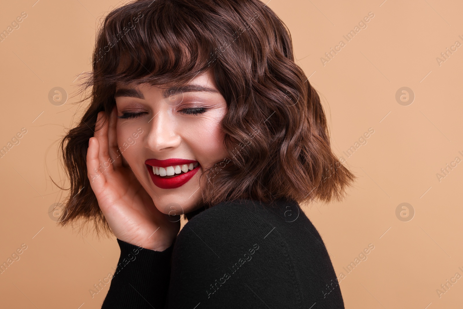 Photo of Portrait of beautiful young woman with wavy hairstyle on beige background