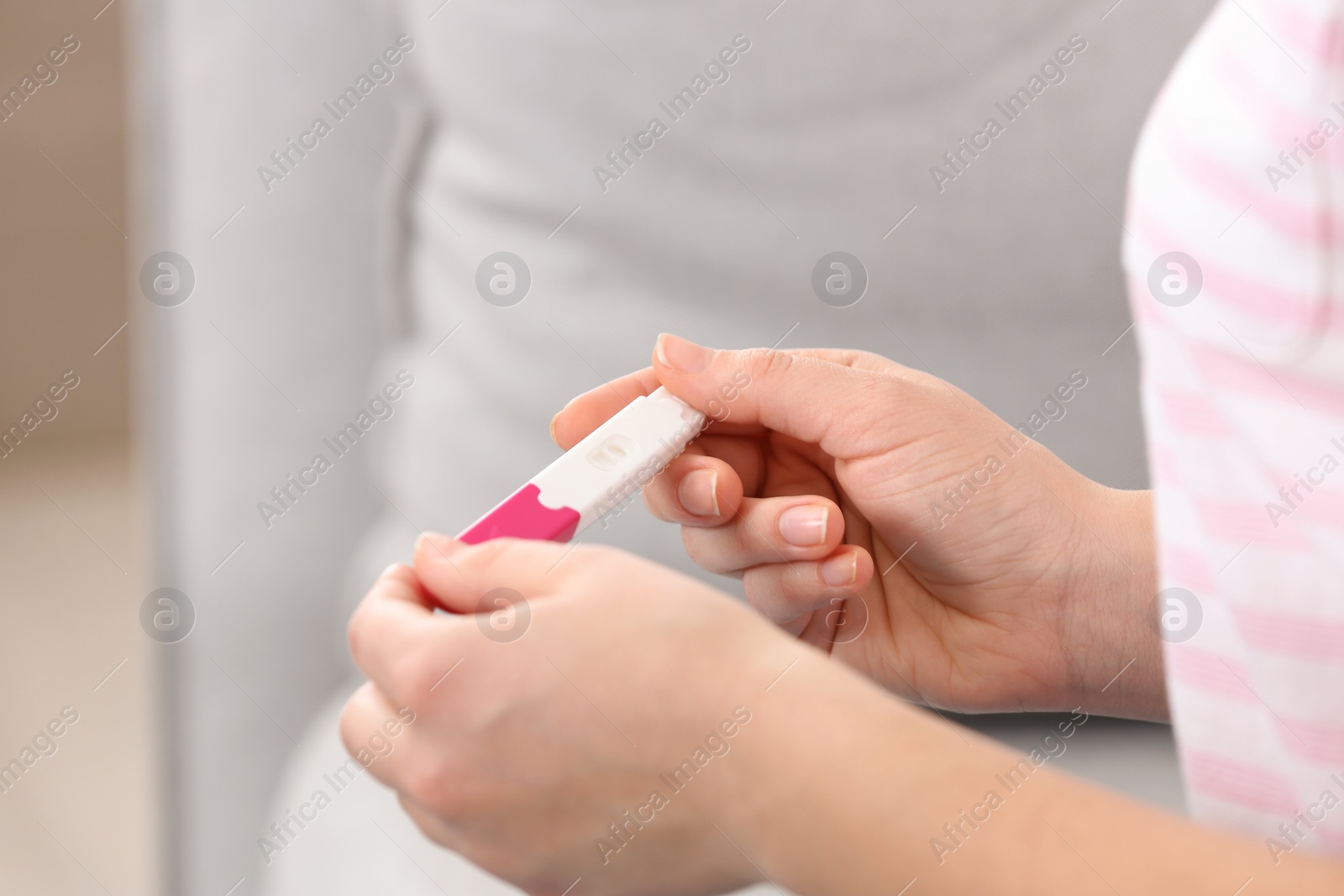 Photo of Young woman with pregnancy test indoors, closeup. Gynecology and childbirth