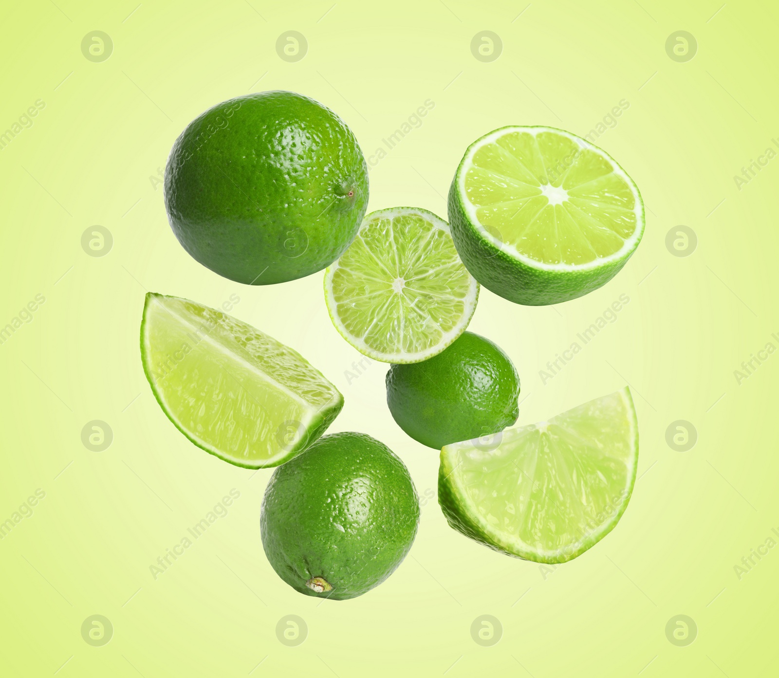 Image of Fresh lime fruits falling on green yellow background