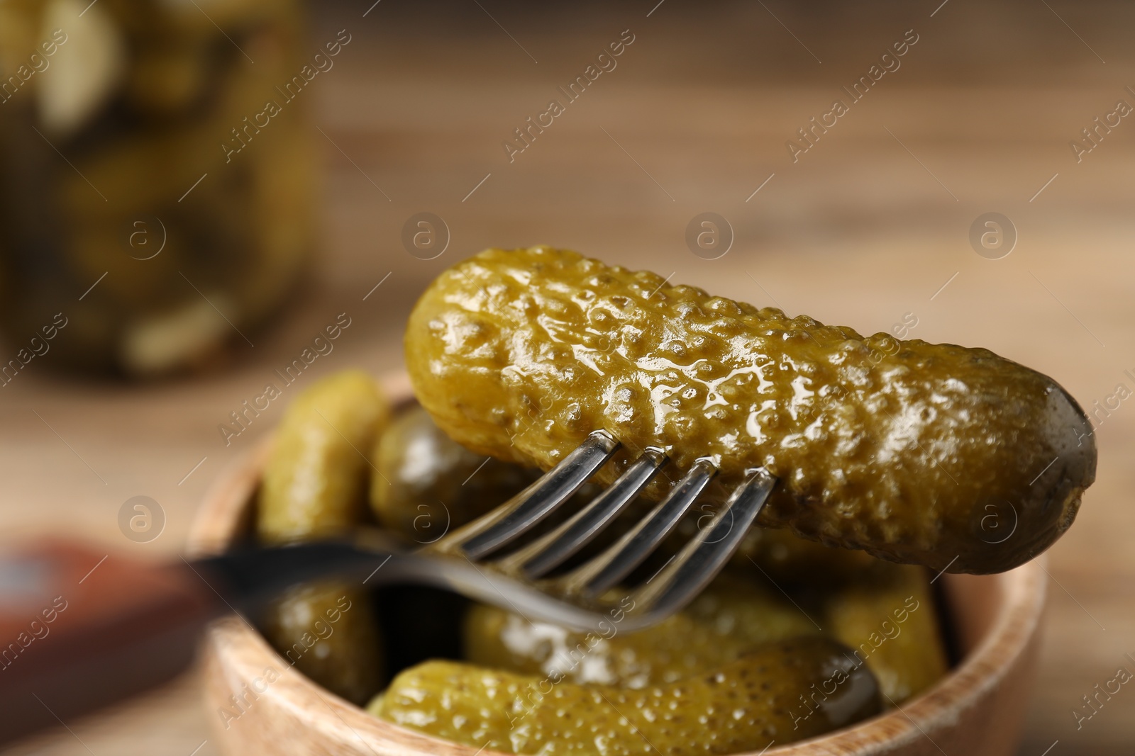 Photo of Eating tasty pickled cucumber at table, closeup