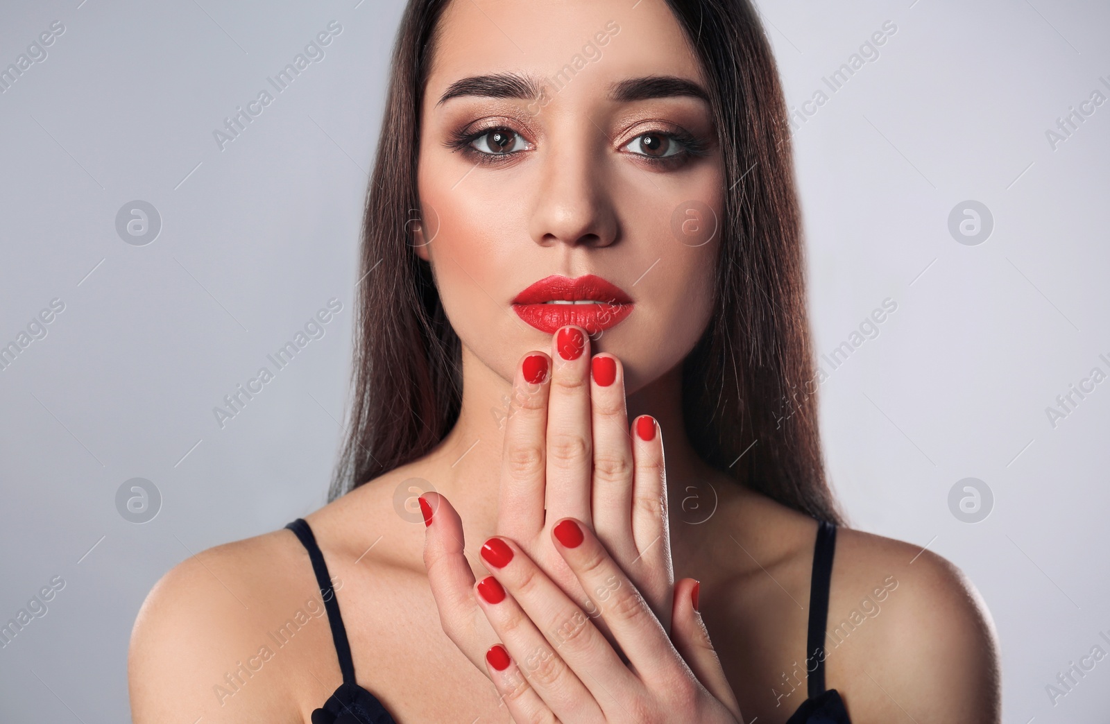 Photo of Beautiful woman with stylish nail polish on grey background