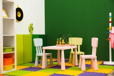 Stylish playroom interior with table and chairs