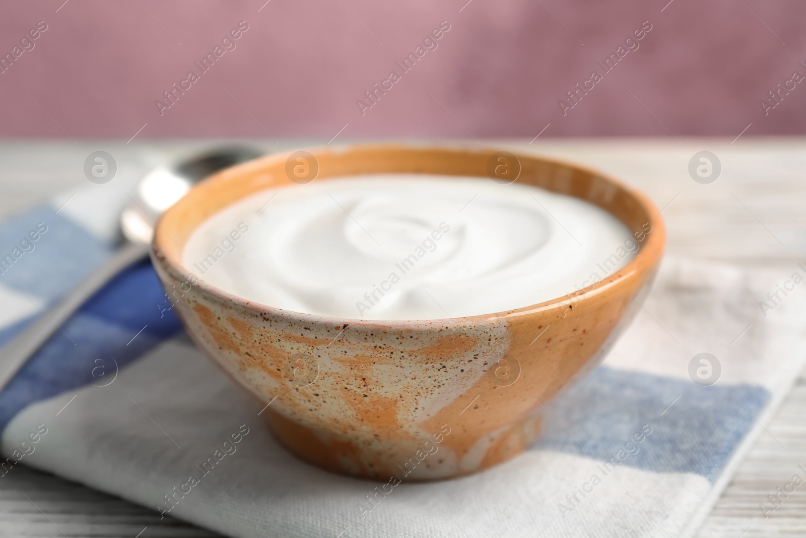 Photo of Bowl with yummy yogurt on wooden table