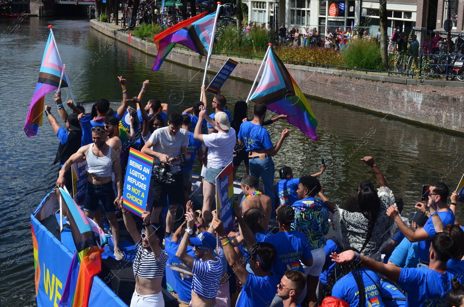 Photo of AMSTERDAM, NETHERLANDS - AUGUST 06, 2022: Many people in boat at LGBT pride parade on river