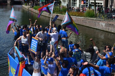 Photo of AMSTERDAM, NETHERLANDS - AUGUST 06, 2022: Many people in boat at LGBT pride parade on river