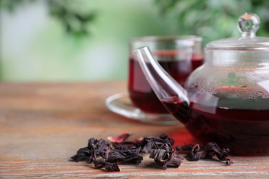 Photo of Freshly brewed hibiscus tea on wooden table, closeup. Space for text