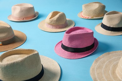 Photo of One pink hat among others on turquoise background. Diversity concept