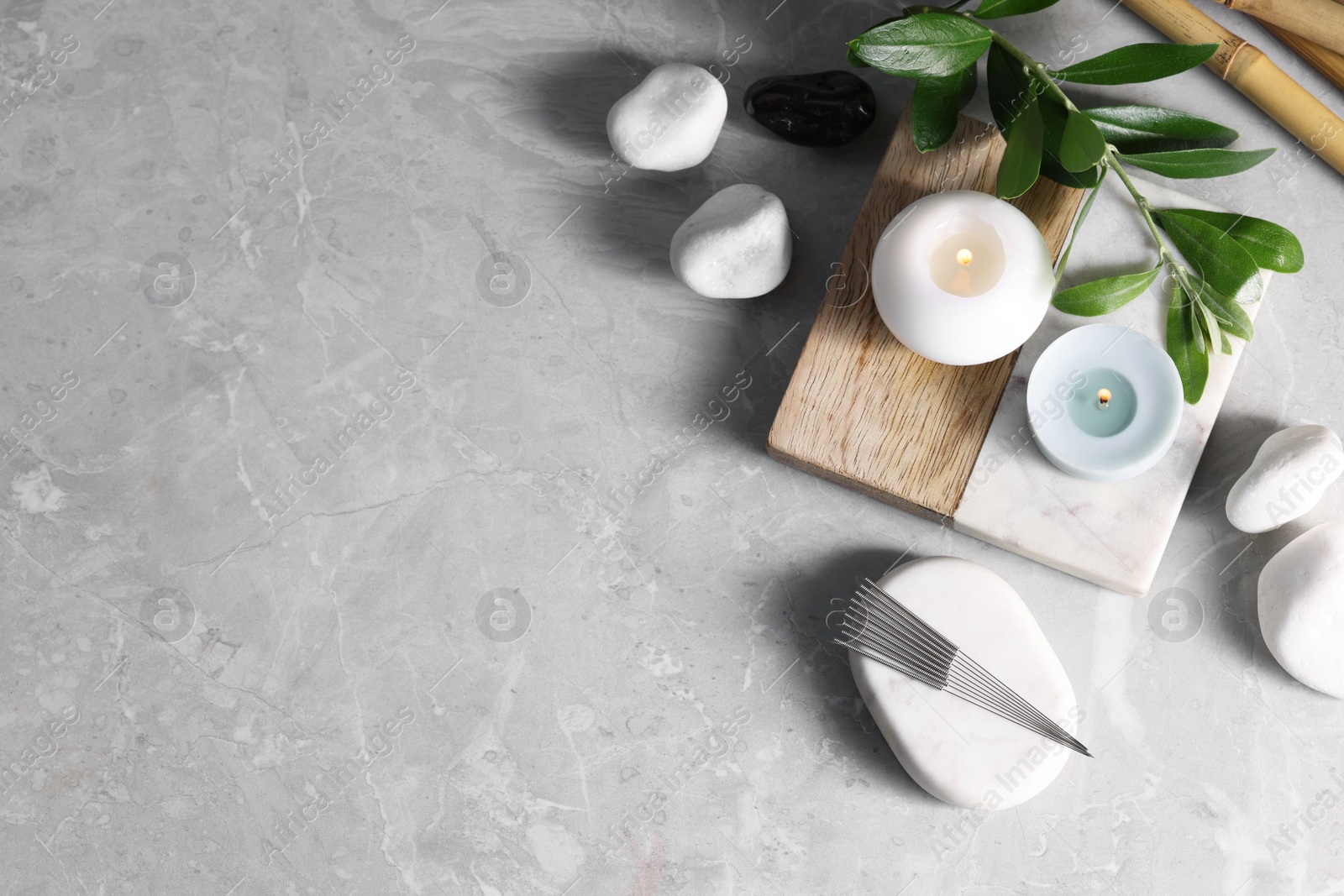 Photo of Flat lay composition with acupuncture needles on light grey marble table, space for text