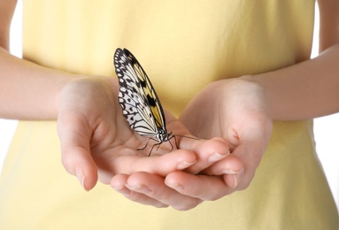 Photo of Woman holding beautiful rice paper butterfly on white background, closeup