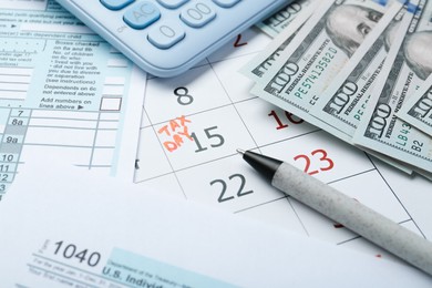 Calendar with date reminder about tax day, documents, money, pen and calculator, closeup