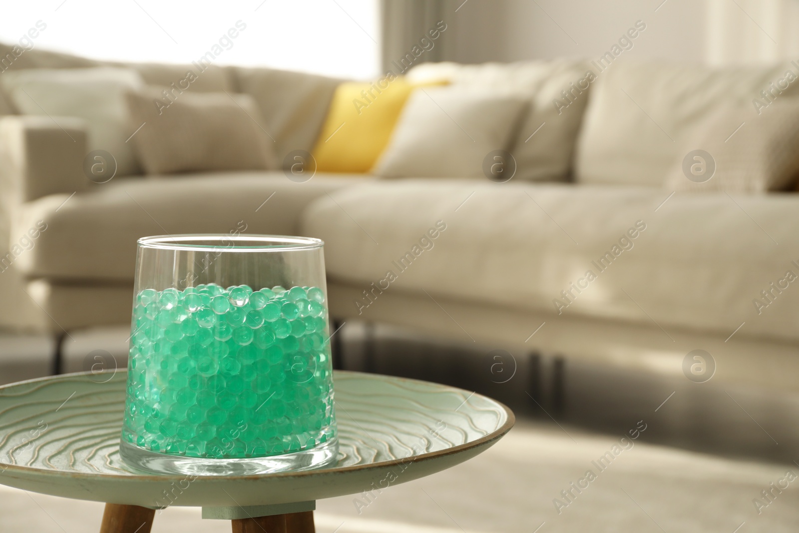 Photo of Mint filler in glass vase on table at home, space for text. Water beads