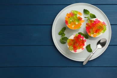 Delicious broken glass jelly dessert on blue wooden table, top view. Space for text