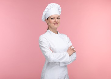 Happy woman chef in uniform on pink background