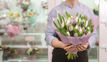 Male florist holding bouquet flowers at workplace