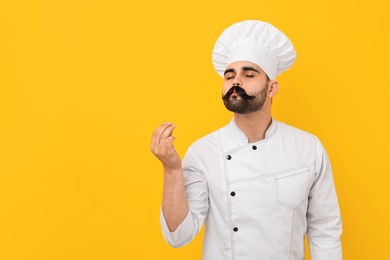 Photo of Professional chef with funny artificial moustache showing perfect sign on yellow background. Space for text
