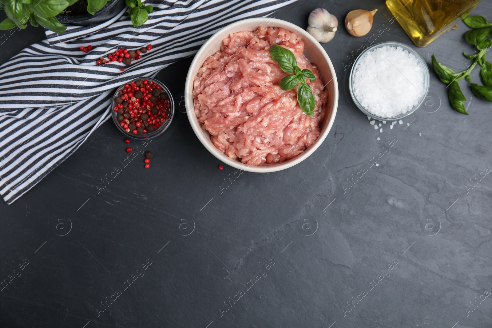 Photo of Raw chicken minced meat and ingredients on black table, flat lay. Space for text