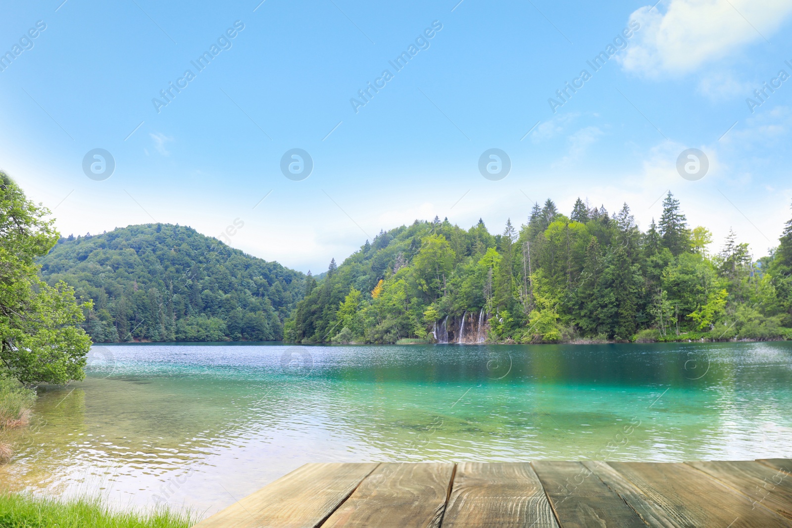 Image of Beautiful view of mountains and wooden pier near river on sunny day