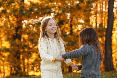 Photo of Happy little girls playing in sunny park. Autumn walk