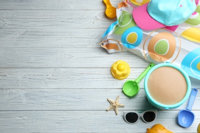 Photo of Flat lay composition with colorful beach toys on wooden background. Space for text