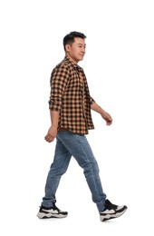 Handsome man in casual outfit walking on white background