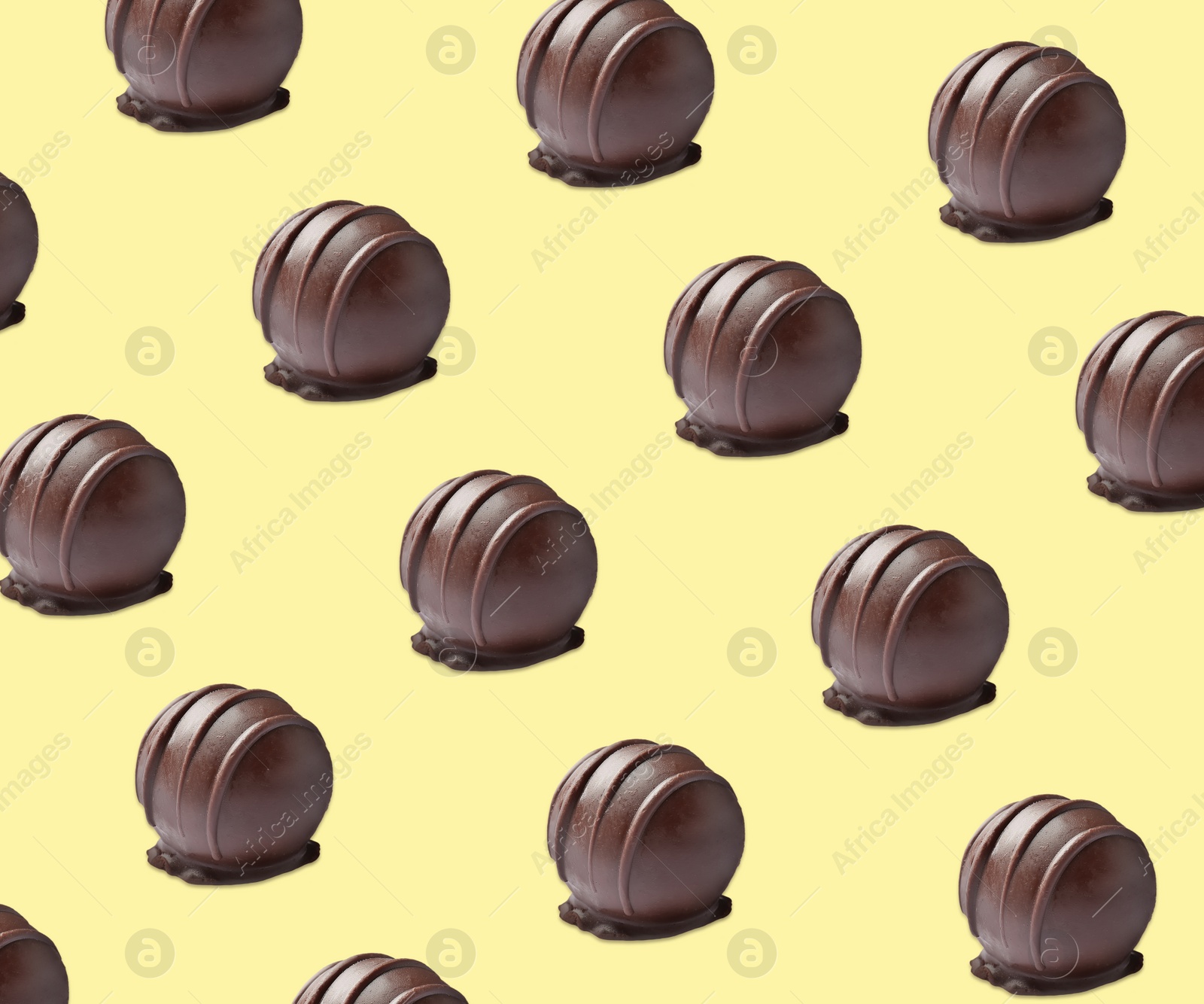 Image of Tasty chocolate candies on pale yellow background. Pattern design