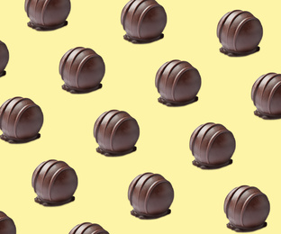 Tasty chocolate candies on pale yellow background. Pattern design