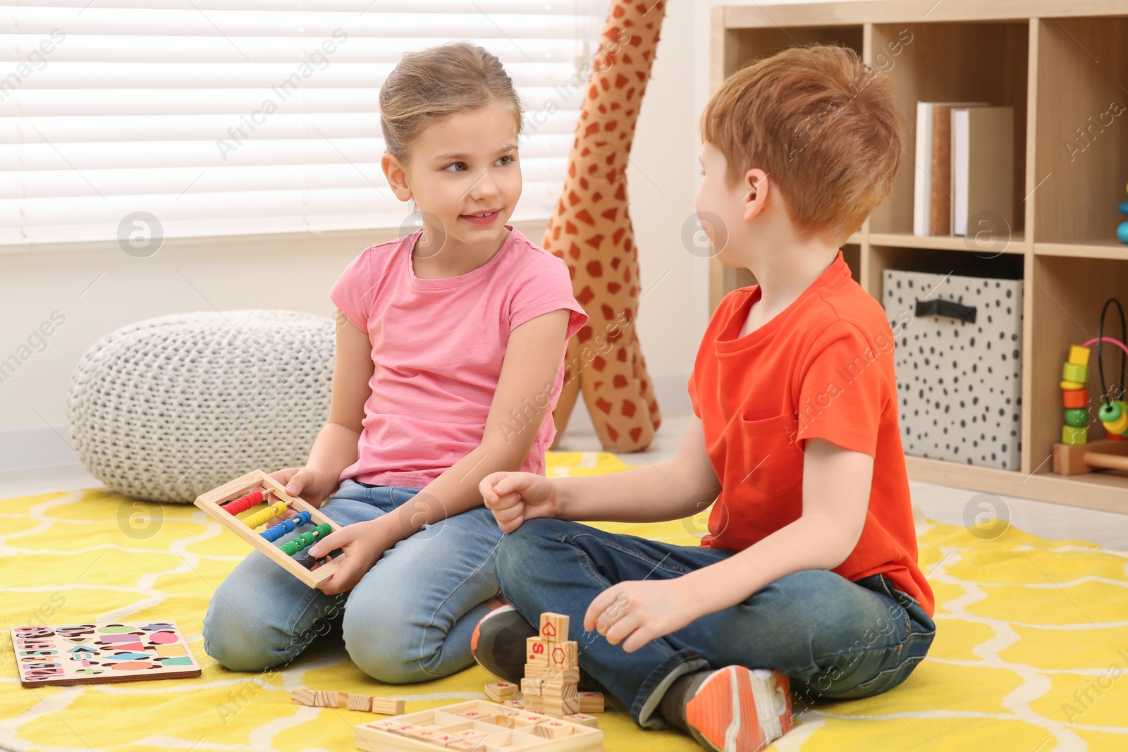 Photo of Children playing with abacus on floor in room. Learning mathematics with fun