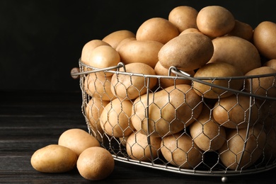 Photo of Raw fresh organic potatoes on wooden table